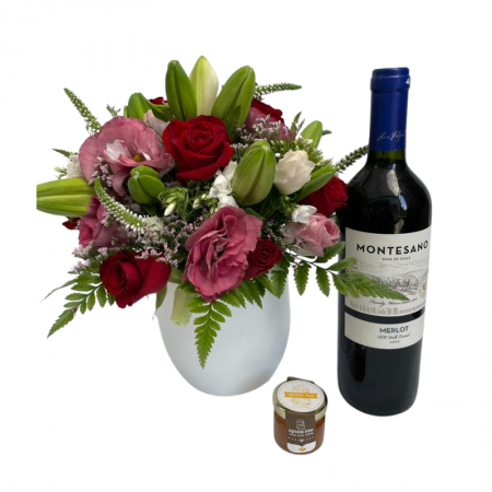 סידור אדום ורוד בכלי עם בקבוק יין ודבש